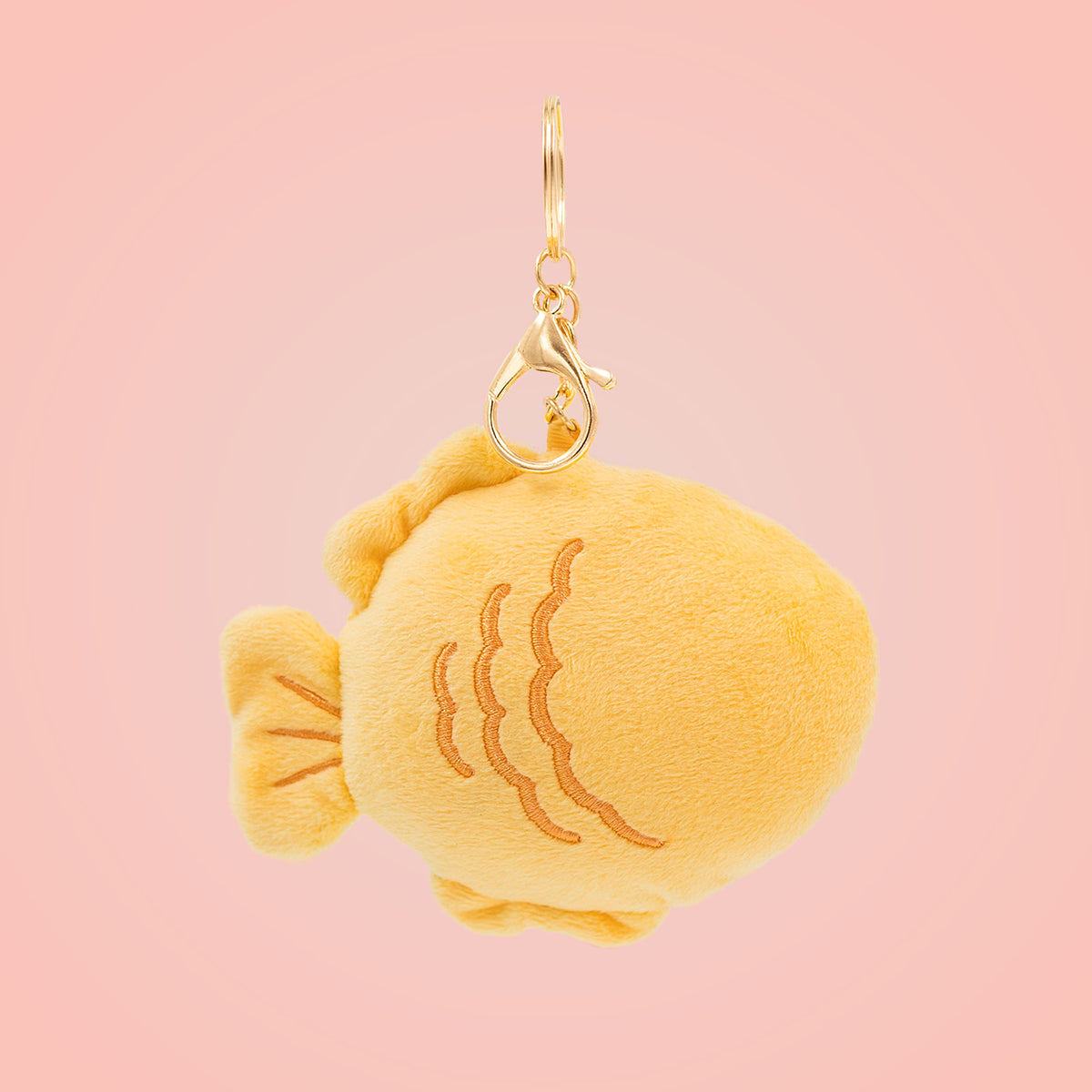 Back view of Japanese taiyaki Food Pals bag charm showing a fish-shaped design with textured details and a gold clasp