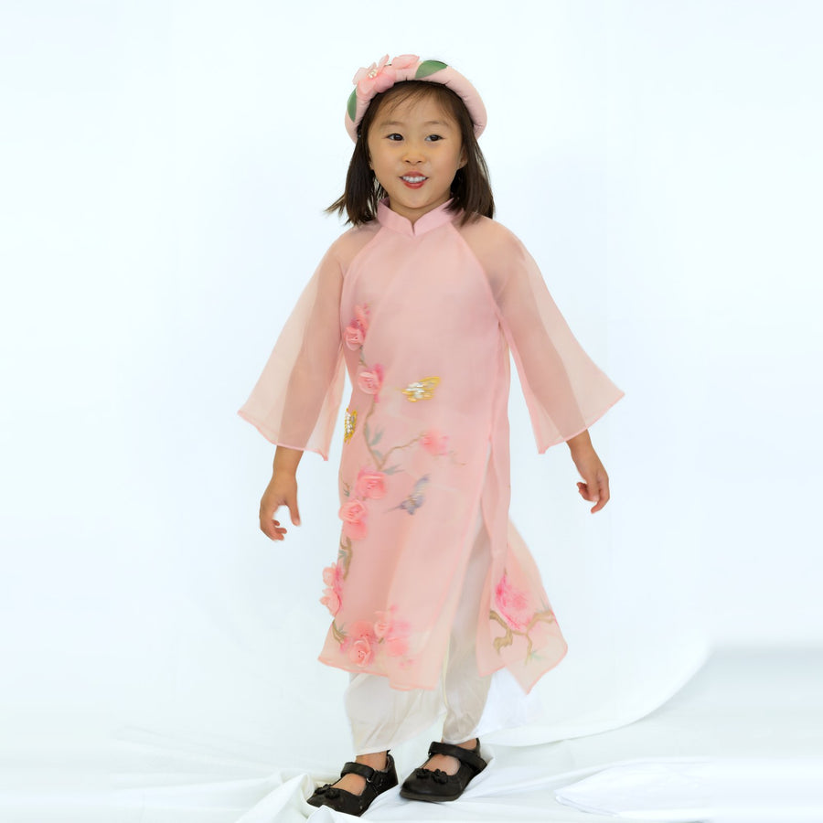 A girl in a pink áo dài by Ao Dai by Cute Sass, matching Thương's outfit