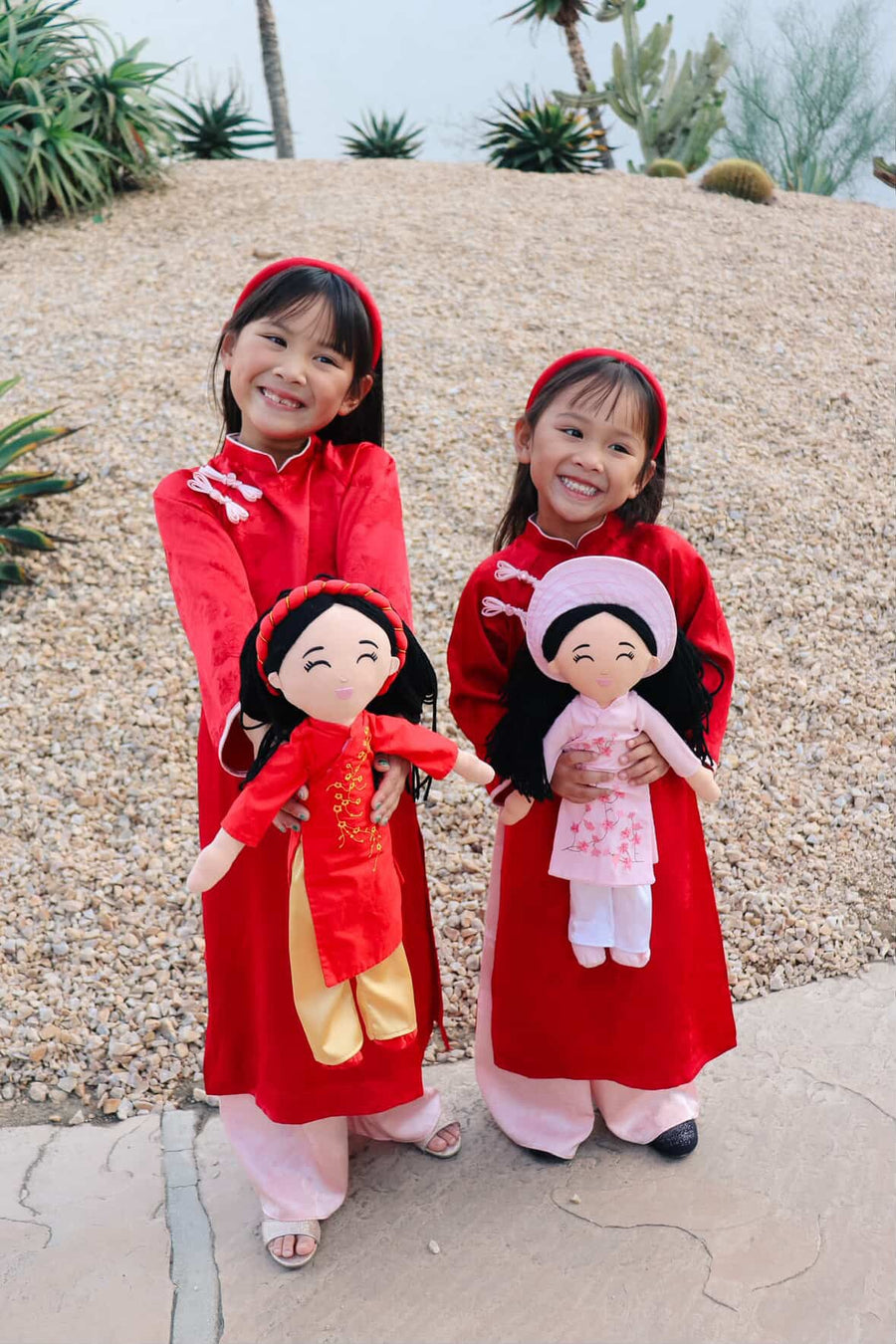 Two sisters in matching áo dài with their Hoa and Thương dolls