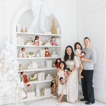 Joeydolls founder Samantha Ong with her husband and two daughters beside shelves of Joeydolls cultural dolls