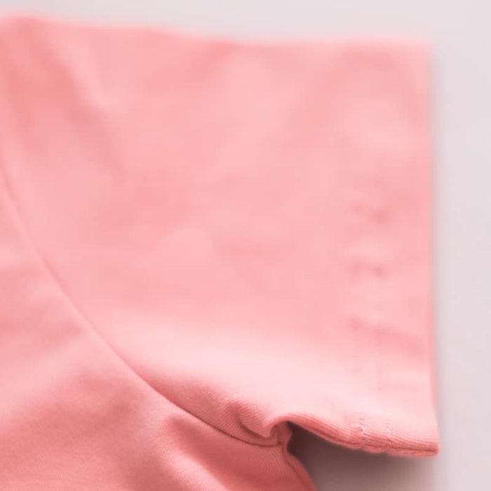 Proudly Asian baby onesie close-up showing soft pink fabric texture and smooth finish.