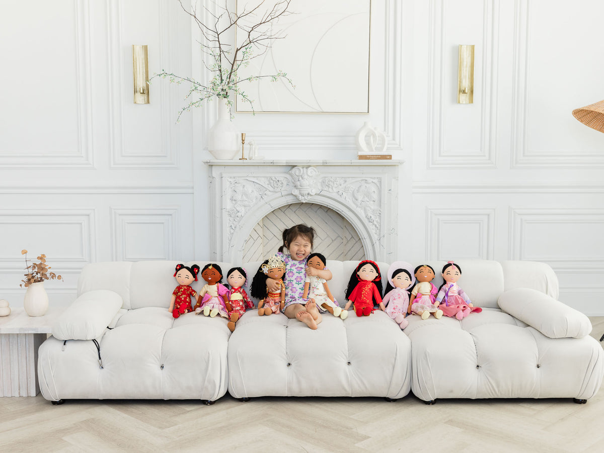 A child sitting with the whole Joeydolls doll collection