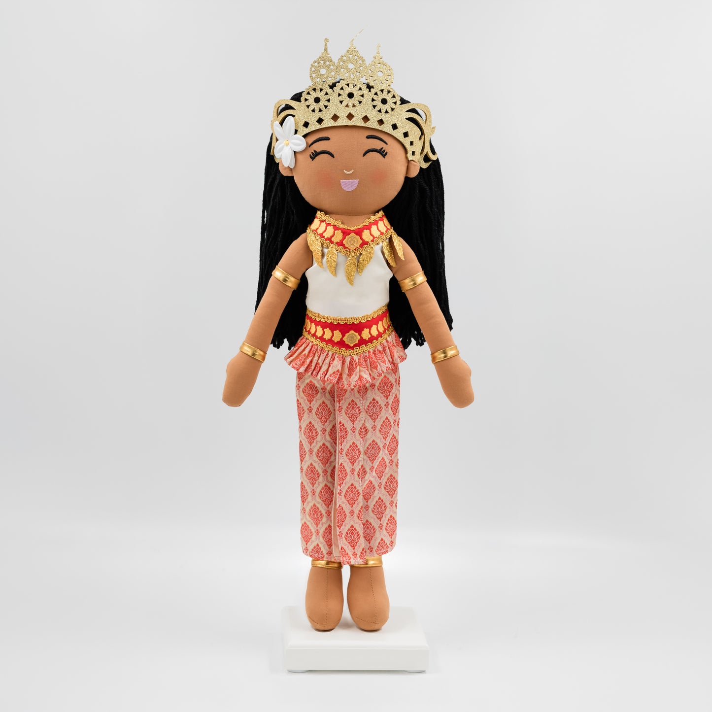 Soriya Cambodian cultural doll wearing a white top and embroidered pink sampot skirt with a gold-red belt, adorned with a gold mokot ksatrey crown and Champei flower in her hair