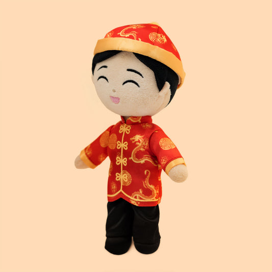 Angled front view of the Chinese Boy Cultural Mini Doll featuring a red and gold traditional Chinese outfit, matching hat, embroidered smile, and soft plush construction for babies and toddlers.