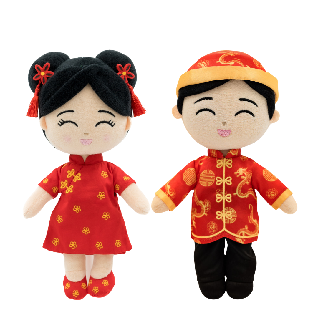 Two plush baby dolls dressed in traditional Chinese wedding attire, featuring a girl in a red dress with gold floral patterns and a boy in a red jacket with gold dragon motifs, set against a plain white background.