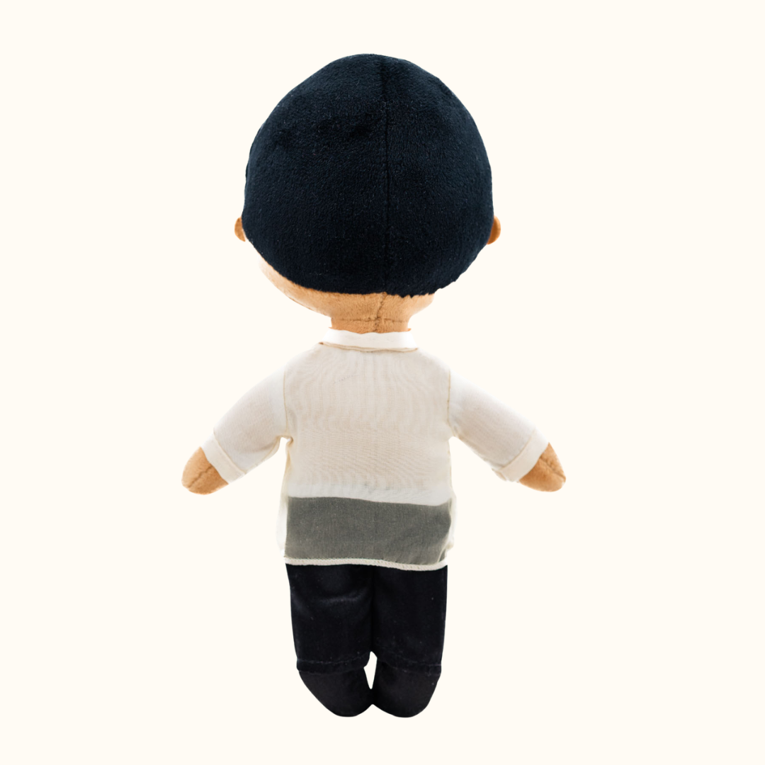 Back view of Bayani Filipino boy mini doll wearing a Barong Tagalog-inspired outfit with a cream embroidered shirt and black pants.