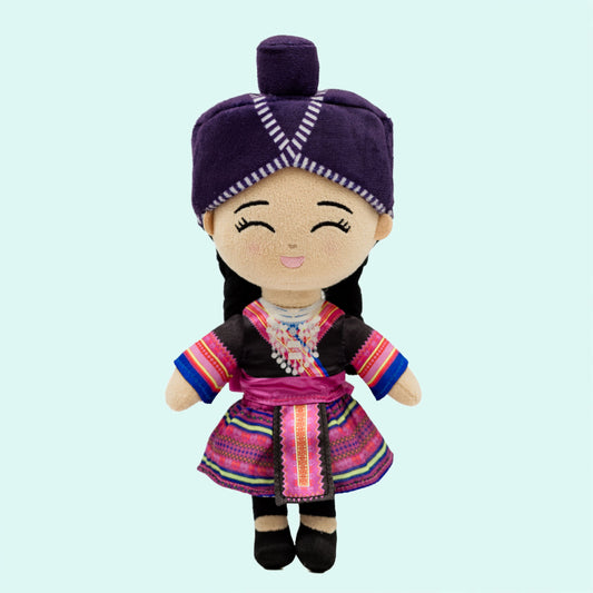 Meet Maiv (pronounced “My”), a soft plush Hmong Cultural Mini Doll for babies and toddlers ages 0–3. She wears a colorful traditional Hmong-inspired outfit with a Hmong head wrap (Phuam Txoom Suab), silver necklace (xauv), braided hair, and a special reversible skirt representing the Hmong White and Hmong Green & Blue communities.
