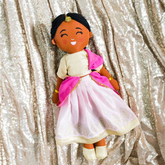 Kamala Indian cultural doll wearing a gold choli top and light pink lehenga with gold embroidery, a pink dupatta, gold jewelry, and a maang tikka in her hair