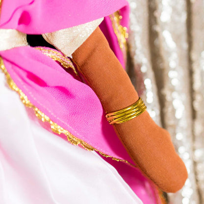Close-up of Kamala doll arm showing shiny gold bangles on her wrist and pink fabric detail