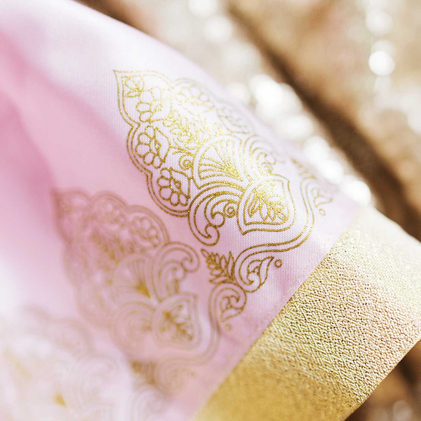 Close-up of Kamala doll outfit showing gold embroidery on lehenga fabric