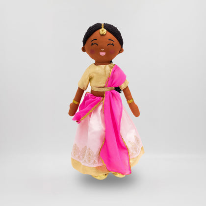 Kamala Indian cultural doll wearing a gold choli top and light pink lehenga with gold embroidery, a pink dupatta, gold jewelry, and a maang tikka in her hair