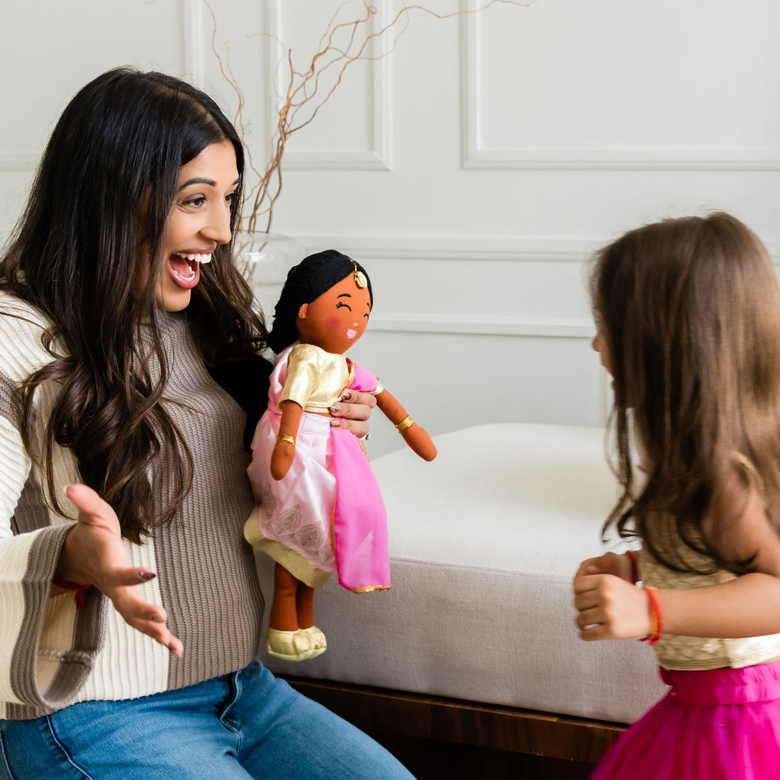 Adult and child playing with Kamala Indian cultural doll, showing joyful and shared cultural play