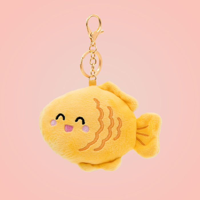 Japanese taiyaki Food Pals keychain featuring a smiling yellow fish-shaped design and a gold clasp