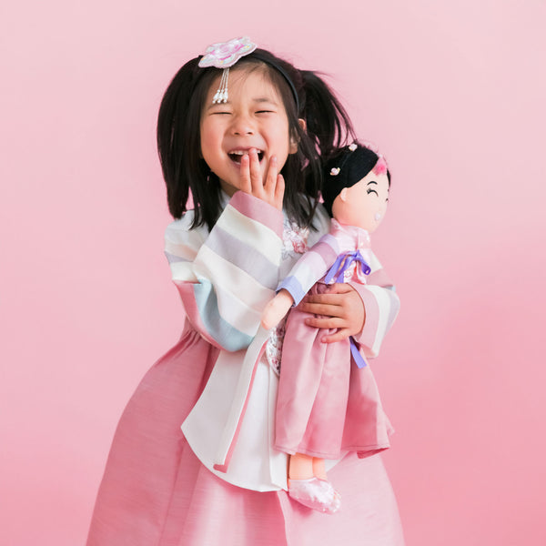 Young girl holding a Korean Danbi cultural doll