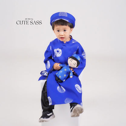 Child wearing a blue áo dài while holding a Minh Vietnamese cultural mini doll dressed in matching traditional attire