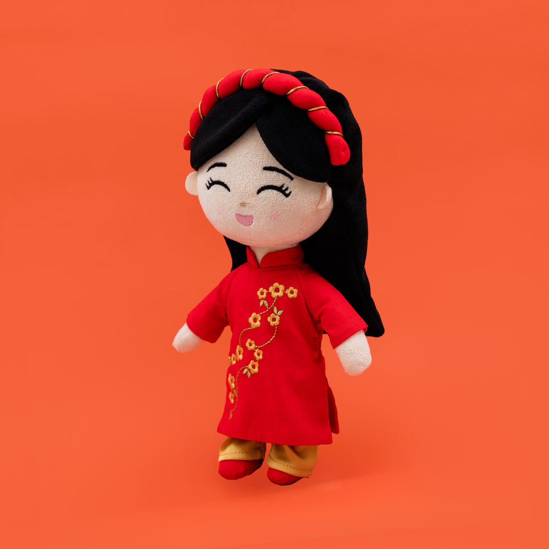 Side view of Hoa Vietnamese cultural mini doll wearing a red áo dài with floral embroidery and gold trousers