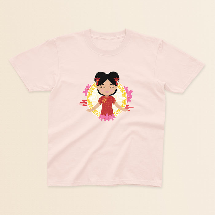 Chinese Cultural Celebration baby and kids tee in light pink featuring a smiling girl with black hair styled in double buns and red accessories, wearing a red and gold qipao, set against a circular gold pattern with pink floral details.