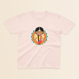 Indian Cultural Celebration baby and kids t-shirt in light pink with a graphic of a smiling girl with long black braided hair with gold maang tikka, wearing a yellow lehenga paired with pink dupatta, set against a mandala-inspired decorative background with a lotus flower at the bottom.