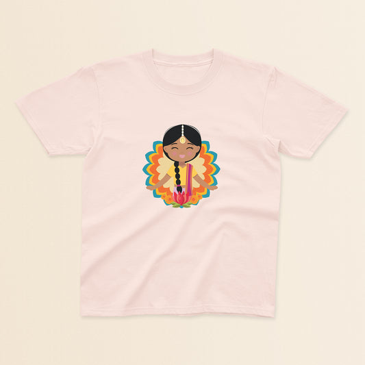 Indian Cultural Celebration baby and kids t-shirt in light pink with a graphic of a smiling girl with long black braided hair with gold maang tikka, wearing a yellow lehenga paired with pink dupatta, set against a mandala-inspired decorative background with a lotus flower at the bottom.
