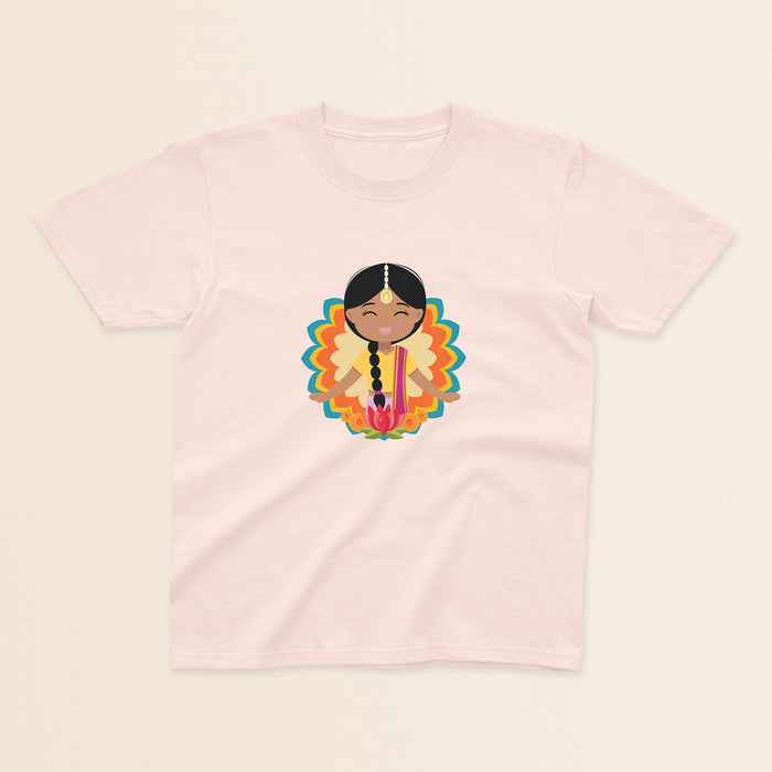 Indian Cultural Celebration baby and kids t-shirt in light pink with a graphic of a smiling girl with long black braided hair with gold maang tikka, wearing a yellow lehenga paired with pink dupatta, set against a mandala-inspired decorative background with a lotus flower at the bottom.