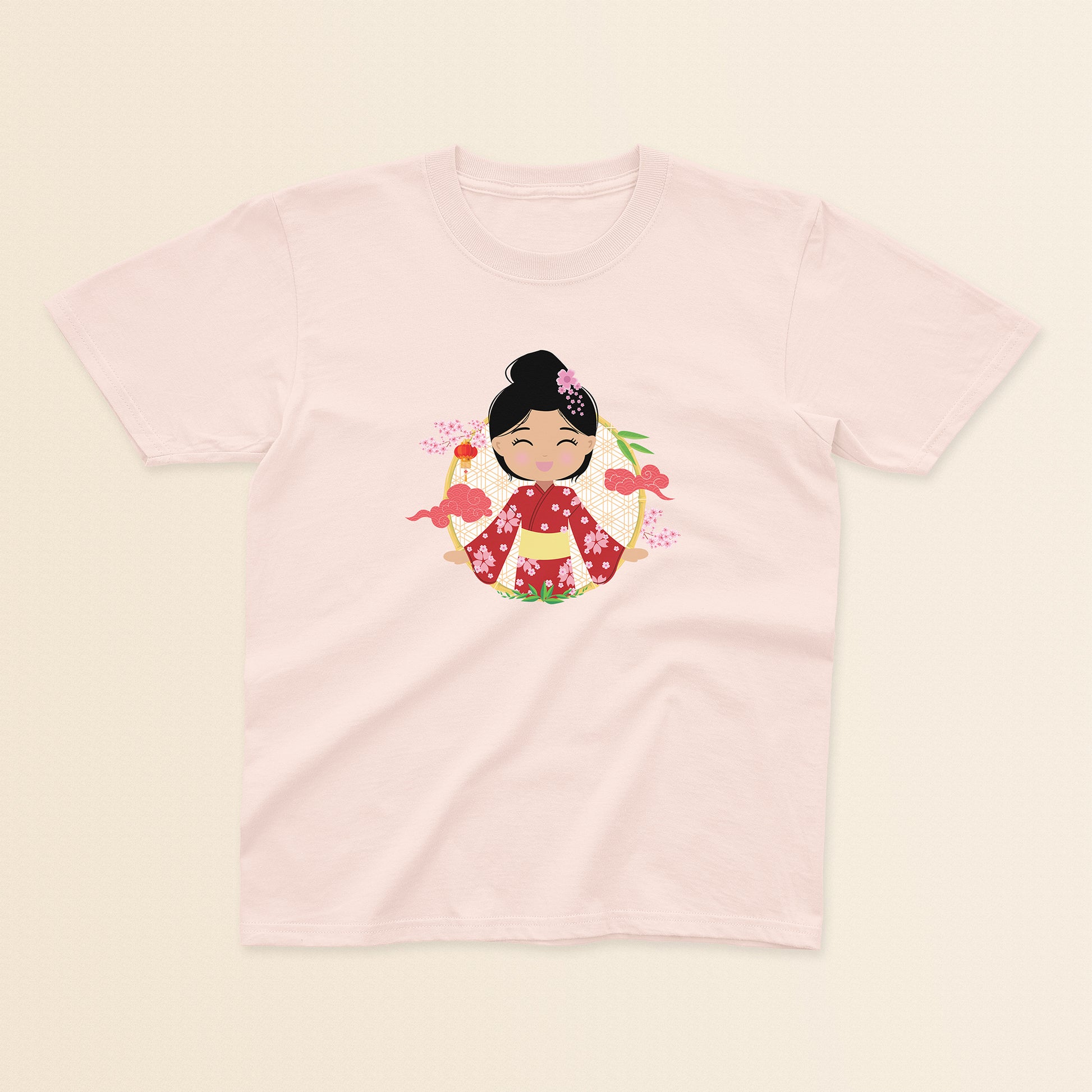 Japanese Cultural Celebration baby and kids t-shirt in light pink with a graphic of a smiling girl with her hair in a high bun with a pink flower, wearing a red sakura-patterned kimono with a yellow obi sash, set against a circular background with cherry blossoms and traditional elements.