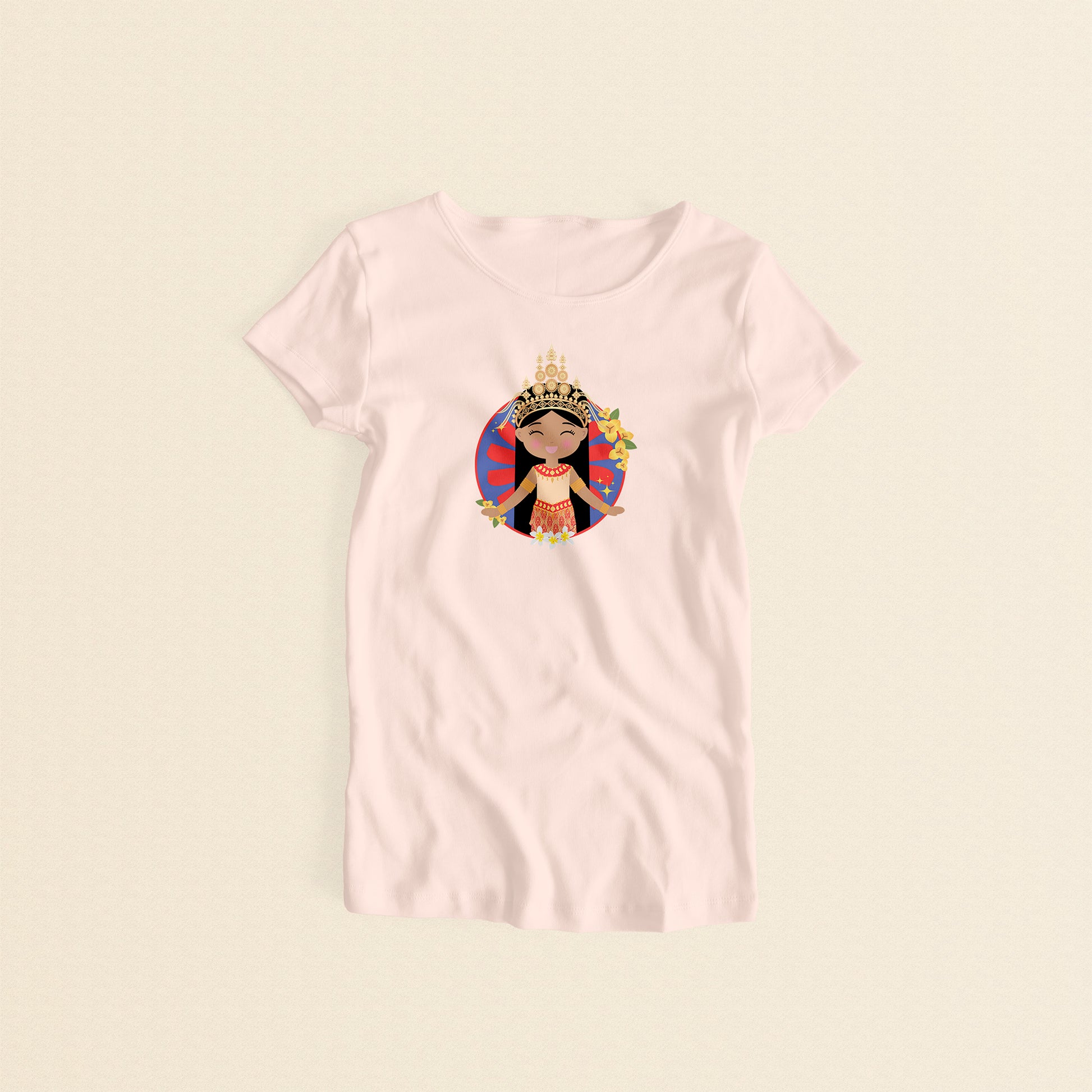 Cambodian Cultural Celebration women’s tee in light pink featuring a smiling girl wearing a sampot and a mokot ksatrey crown set against a circular red and blue radiating pattern (sunburst) adorned with champei flowers and yellow flowers.