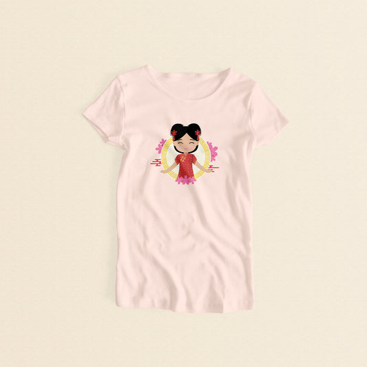 Chinese Cultural Celebration women’s tee in light pink featuring a printed illustration of a smiling girl with her hair in two buns adorned with red accessories, wearing a vibrant red and gold qipao, set against a circular gold pattern with pink floral elements.