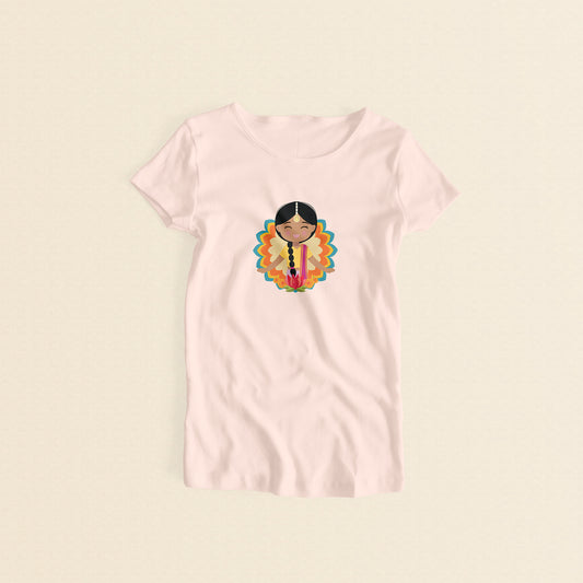 Indian Cultural Celebration women’s tee in light pink featuring a printed illustration of a smiling girl with long black braided hair with gold maang tikka, wearing a yellow lehenga paired with pink dupatta, set against a mandala-inspired decorative background with a lotus flower at the bottom.