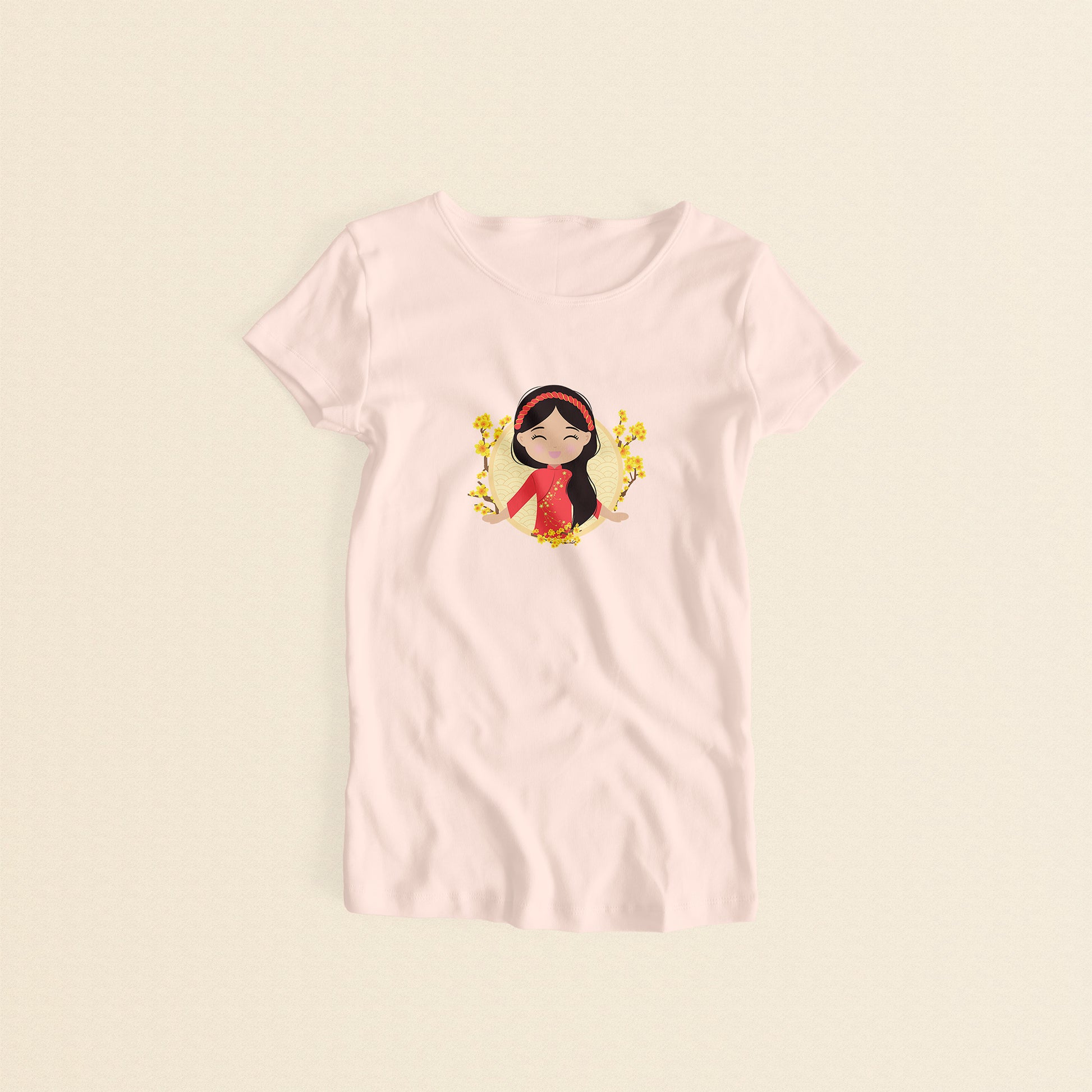 Vietnamese Cultural Celebration women’s tee in light pink featuring a printed illustration of a smiling girl with long black hair, wearing a red áo dài with delicate mai flower details and a traditional khăn đóng headpiece, set against a circular Seigaiha wave pattern background with yellow mai flower branches on both sides.