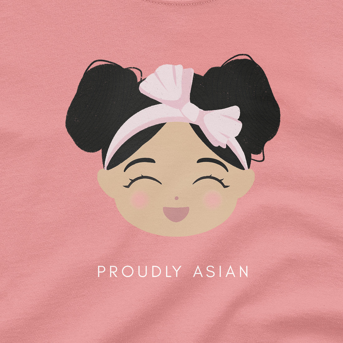 Proudly Asian baby onesie close-up showing a smiling girl graphic with double buns and a pink headband, with “Proudly Asian” text below.