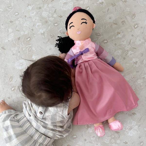 Baby playing with a cultural doll