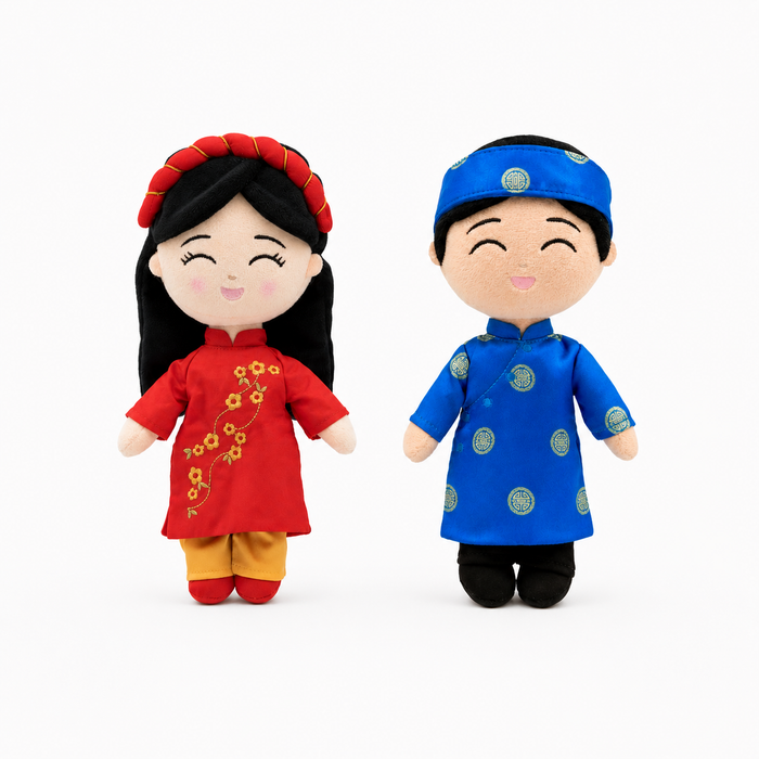 Two Vietnamese cultural mini dolls wearing a blue áo dài and a red áo dài with a khăn đóng headpiece.