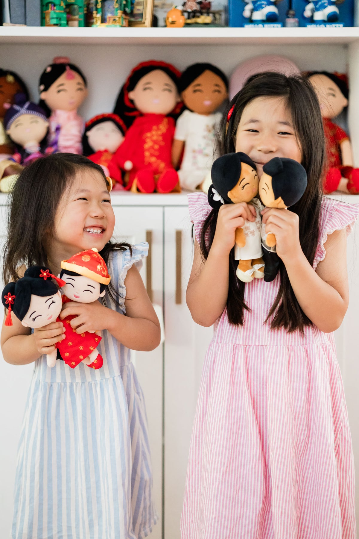 Two children holding culturally diverse Joeydolls while playing together