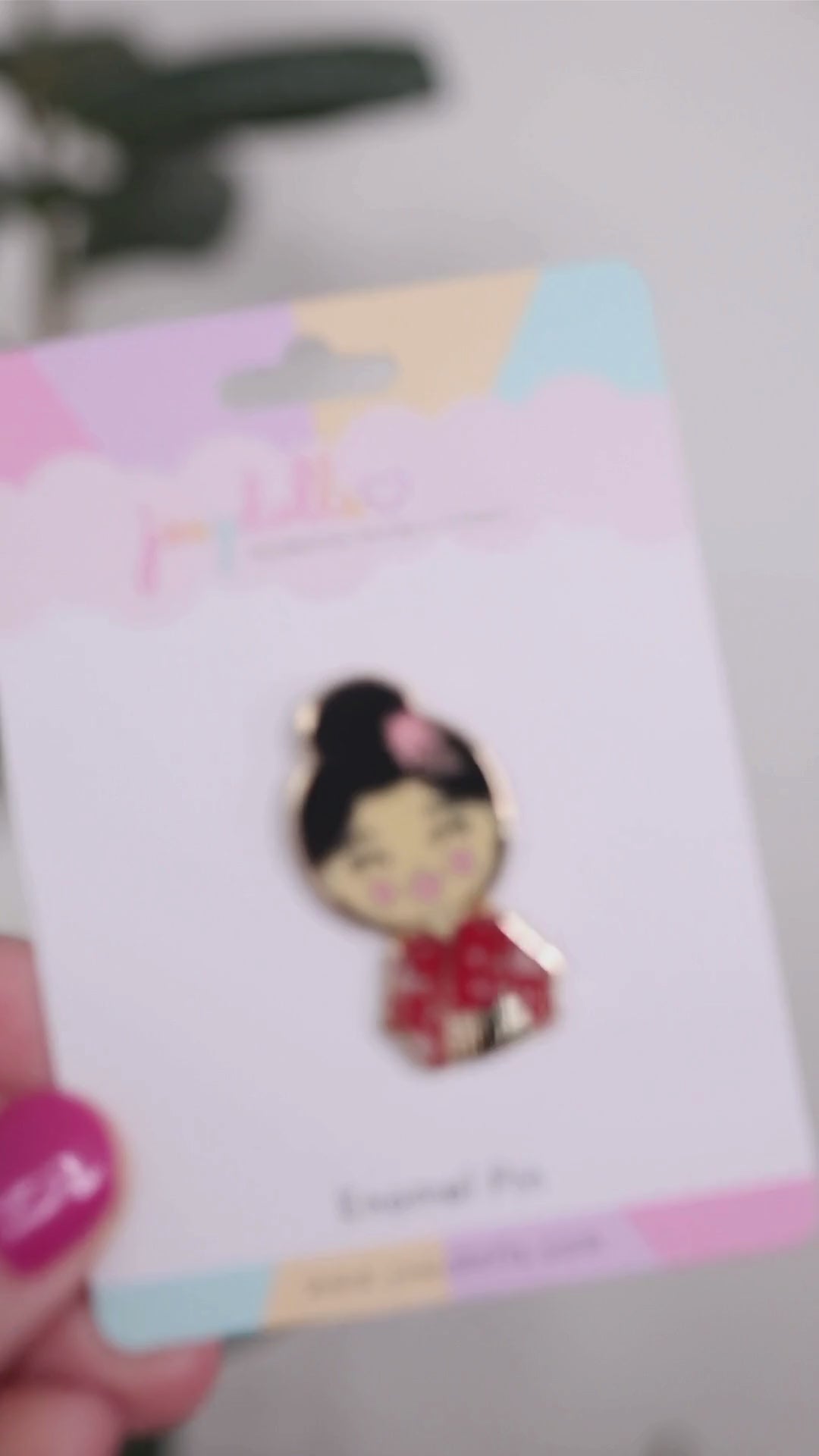 Joeydolls Japanese Aiko gold enamel pin on a Joeydolls display card, gently moving to show its floral outfit details, hair accessory, and glossy finish.