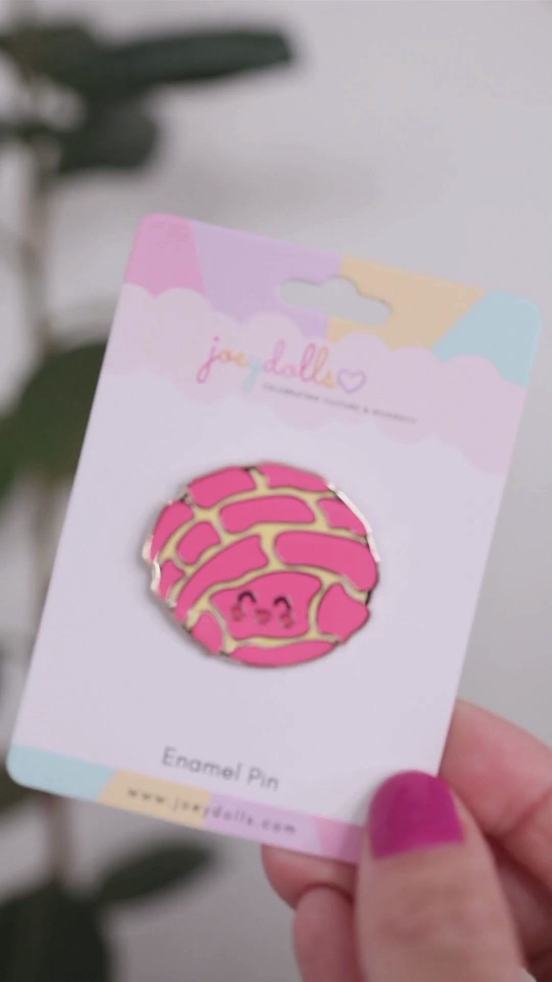 Concha Mexican sweet bread enamel pin on a Joeydolls display card, gently moving to show its pink concha shell pattern and glossy finish.