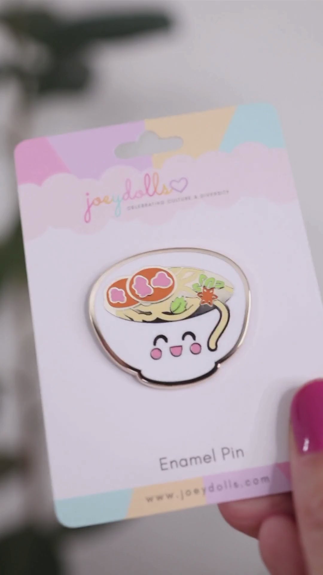 Phở Vietnamese noodle soup enamel pin on a Joeydolls display card, gently moving to highlight its noodle details, toppings, and glossy finish.