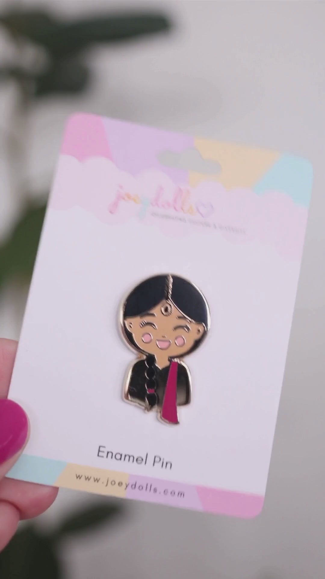 Joeydolls Indian Priya enamel pin on a Joeydolls display card, gently moving to show its lehenga and dupatta details, maang tikka, braid, and glossy finish.