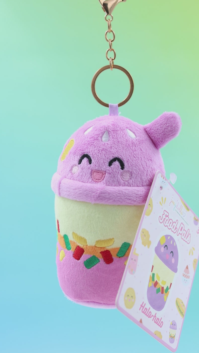 Filipino halo-halo Food Pals bag charm being squeezed and rotated to show its soft texture, with a gold clasp and product tag