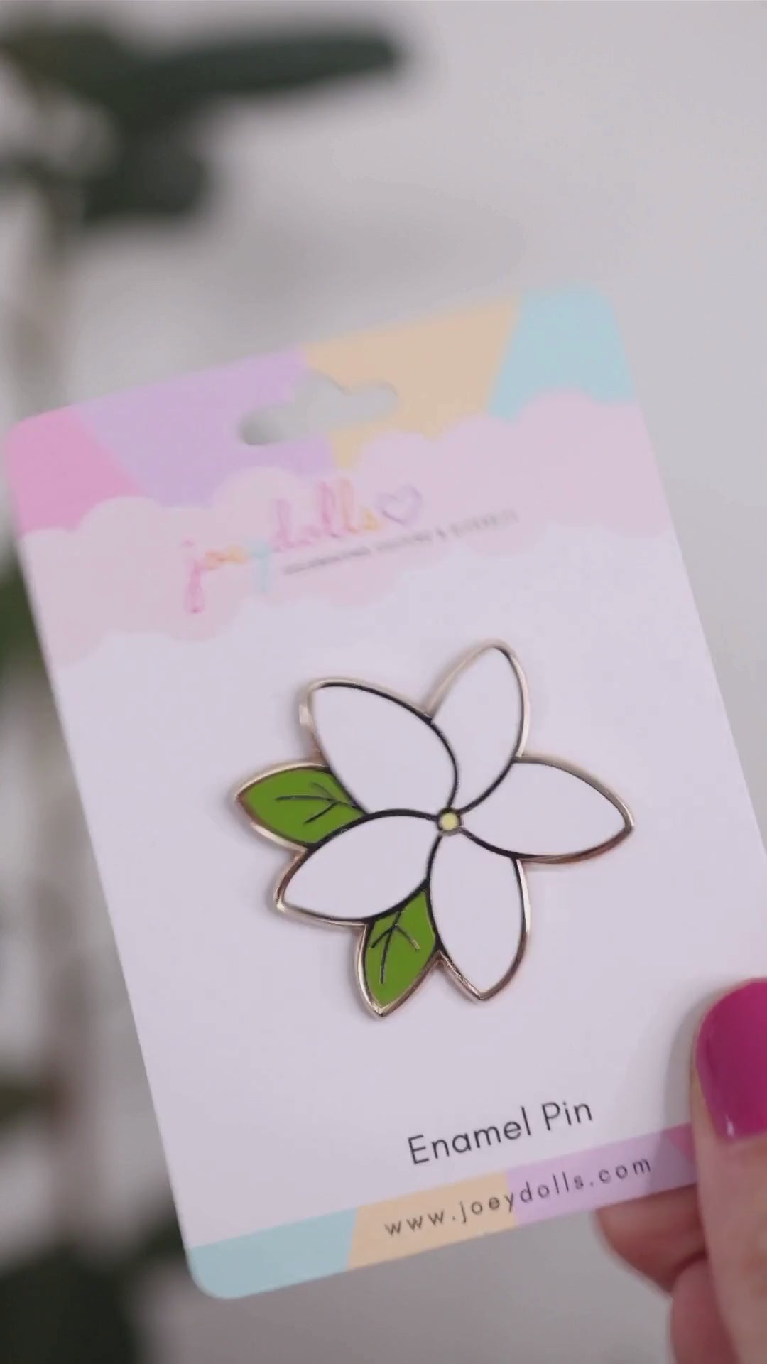 Sampaguita Philippines jasmine flower enamel pin on branded packaging, featuring a white flower with green leaves.