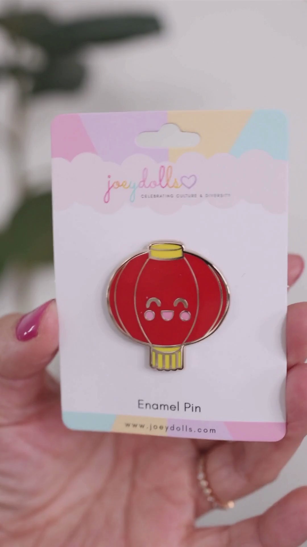 Dēnglóng Chinese lantern enamel pin on a Joeydolls display card, gently moving to show its red lantern shape, yellow accents, and glossy finish.