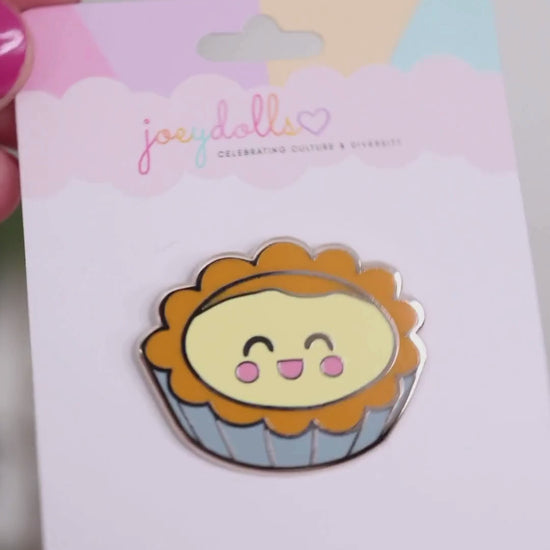 Dàn Tǎ Chinese egg tart enamel pin on a Joeydolls display card, gently moving to show its golden crust, creamy custard filling, and glossy finish.
