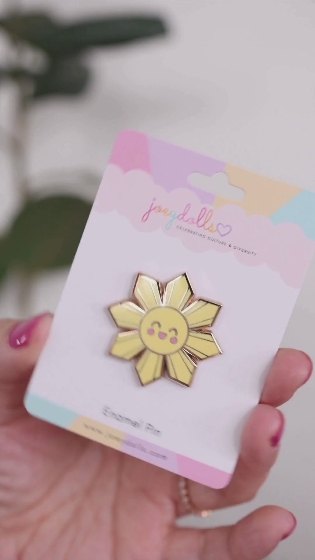 Araw Philippines sun enamel pin being moved while attached to a Joeydolls display card