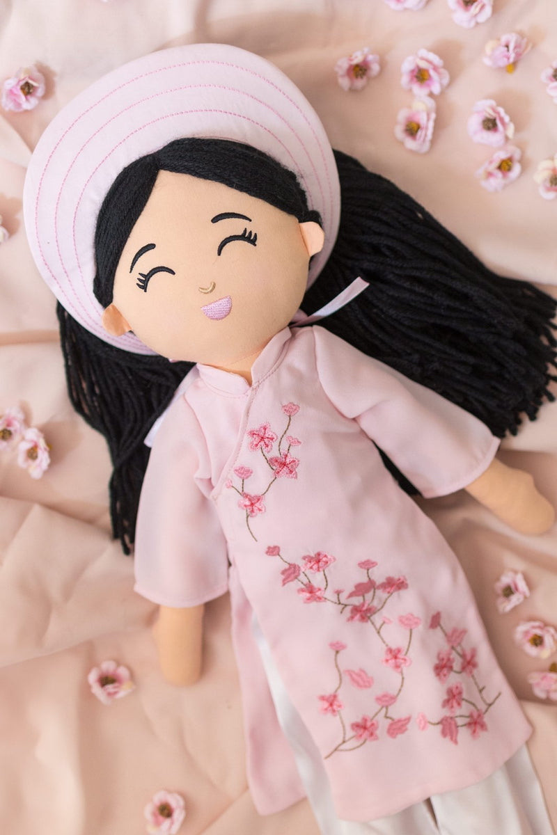 Thương in her pink áo dài among peach blossoms
